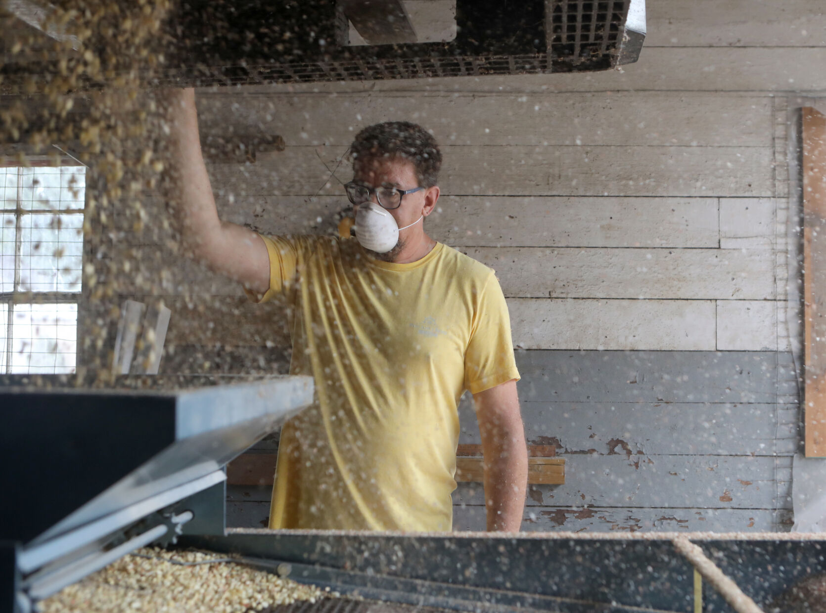 Greg Brinker pours corn into a machine
